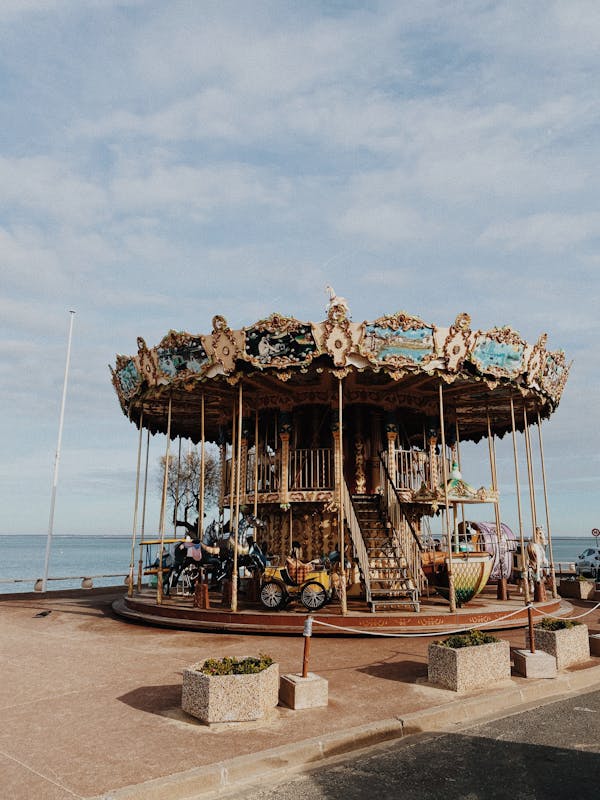 A Carousel Near the River Under Blue Sky