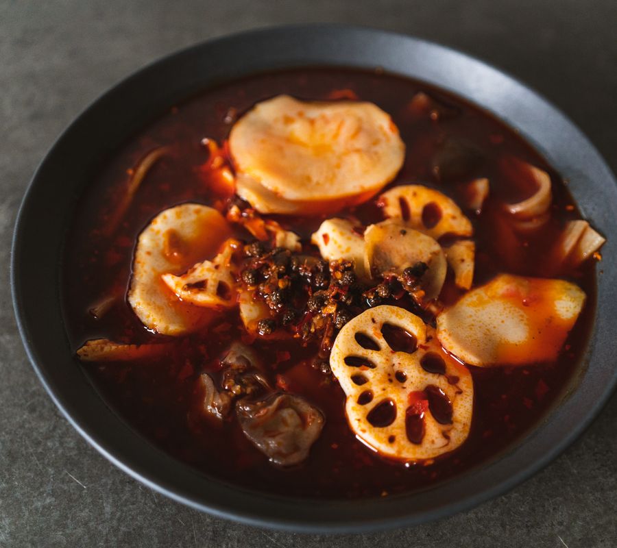 A delicious bowl of Sichuan hotpot featuring lotus roots and potatoes in spicy broth.