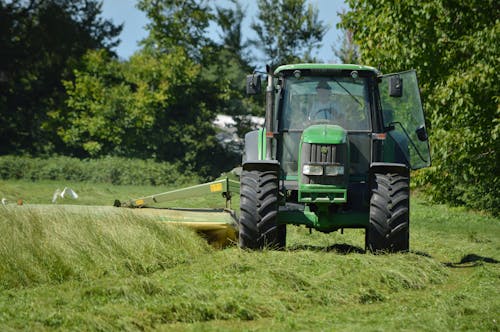 Green Tractor Driving on Grass Field