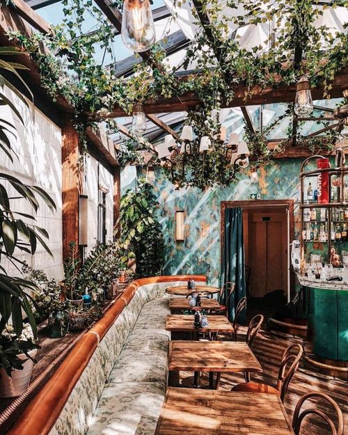 Free Inviting Parisian restaurant interior, filled with lush greenery and vintage charm. Stock Photo