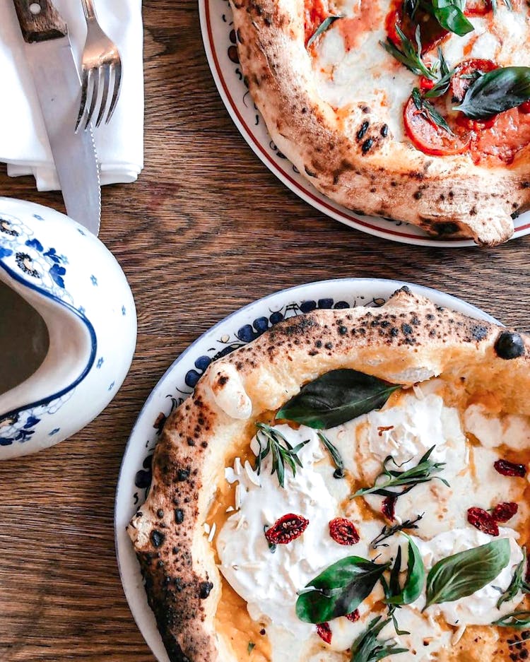 A Close-Up Shot Of Pizzas On A Wooden Table