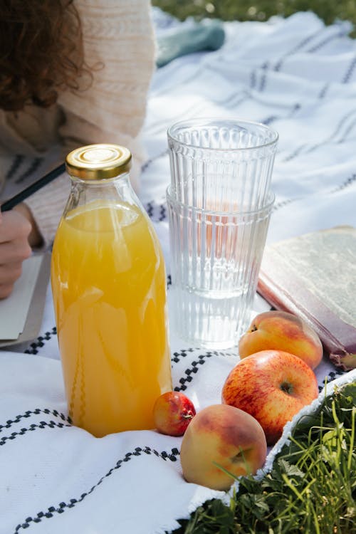 Fruit, Glasses and Juice on Picnic Blanket