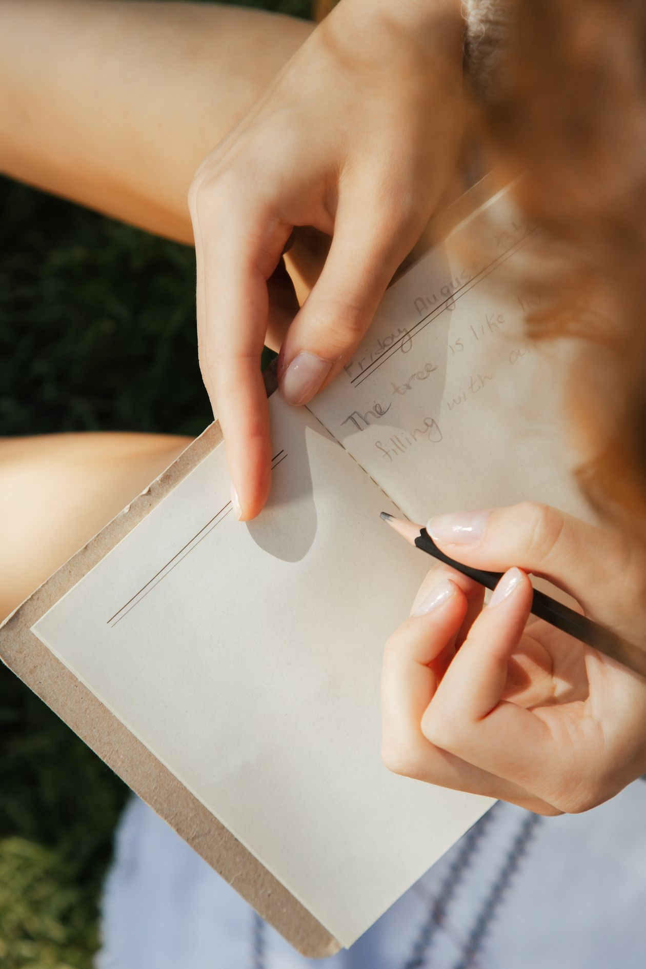 Person writing in a journal on a bed