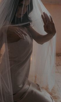 Elegant bride in a soft white dress and veil exudes timeless beauty.