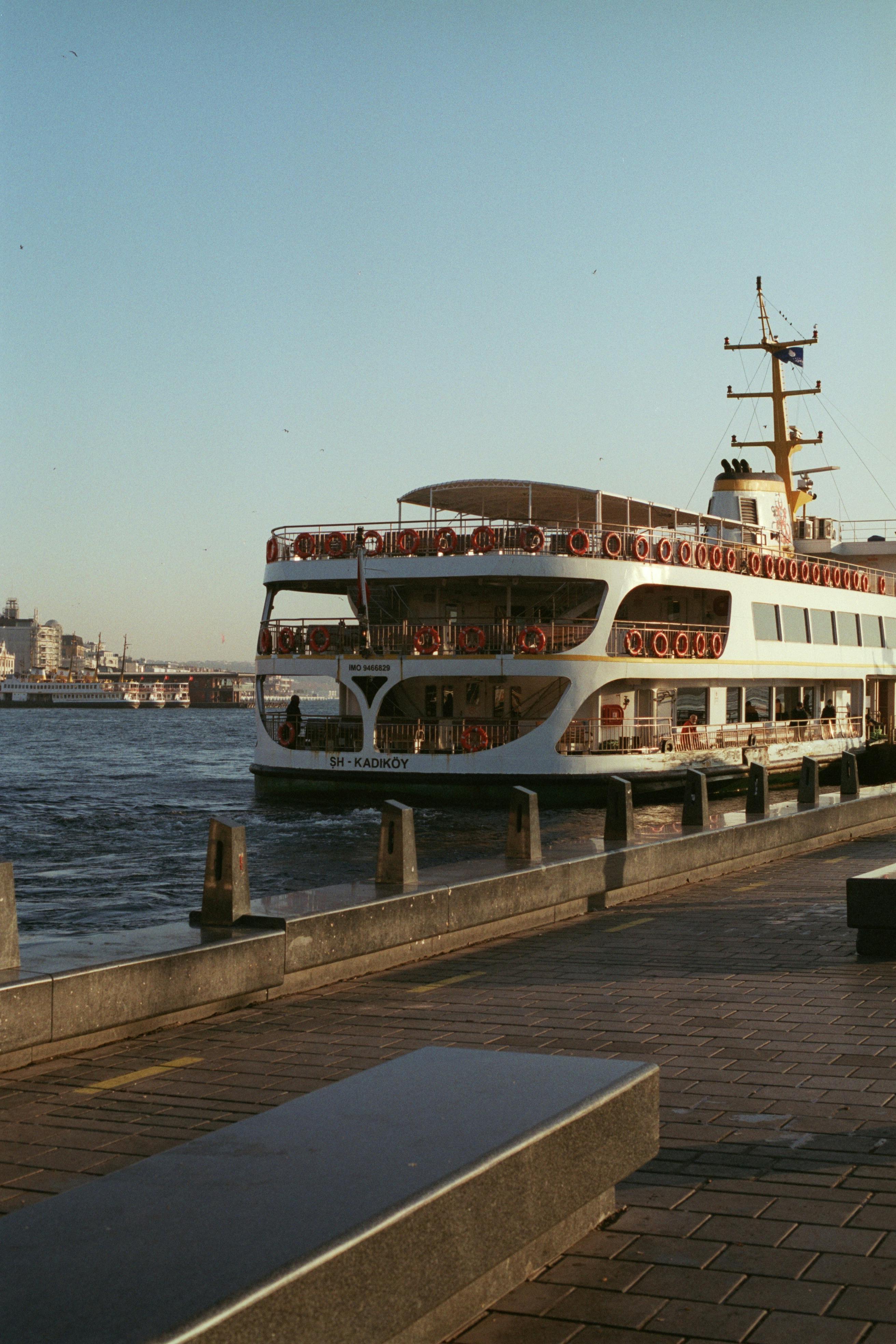 A cruise ship docked along the Bosphorus in Istanbul under a clear sky.
