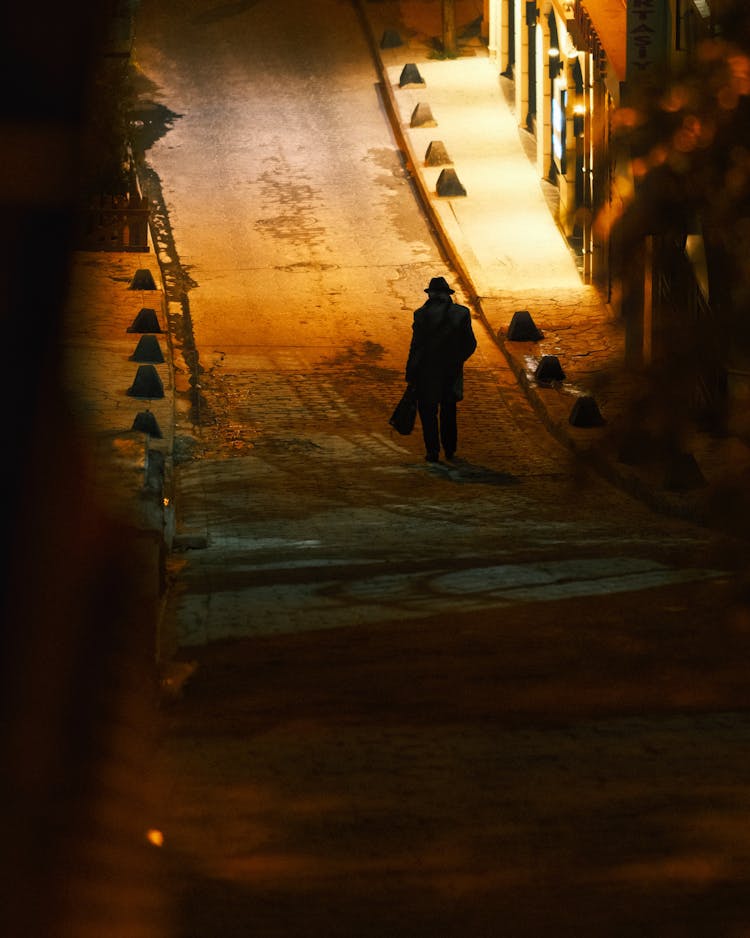 Man Walking Empty City Street At Night