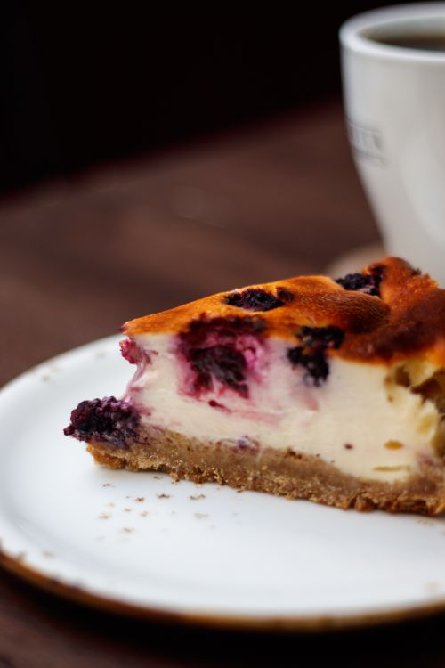 Free Close-up of a berry cheesecake slice with a cup of coffee, perfect for dessert lovers. Stock Photo