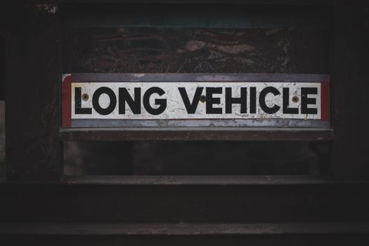 Detailed close-up of a 'Long Vehicle' sign on a metal structure, showcasing industrial signage.