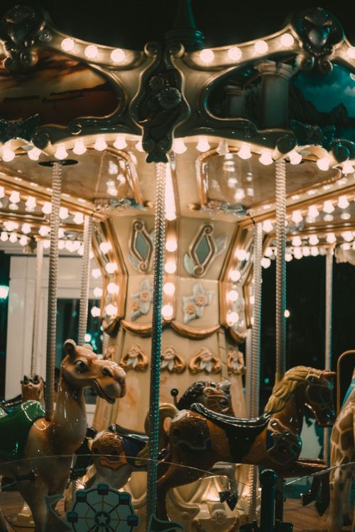 Free Vintage carousel lit up at night with ornate horse figures, capturing a nostalgic and dreamy atmosphere. Stock Photo