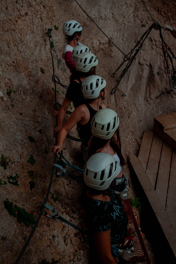 People In Helmets Near Rock