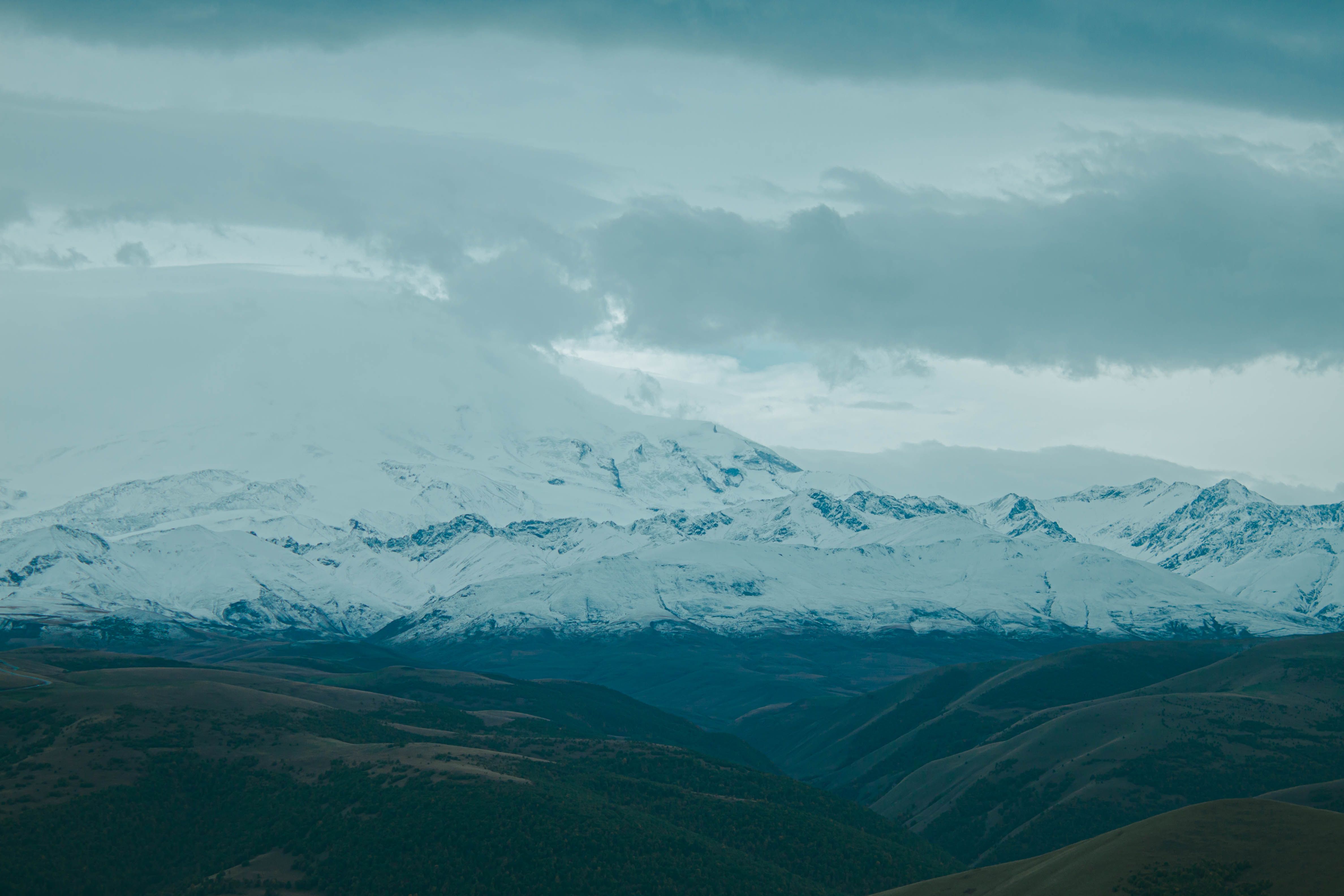 Snow Covered Mountains Under Cloudy Sky · Free Stock Photo