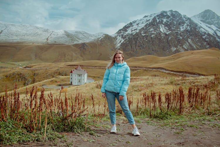 Woman In Jacket With Mountains Behind