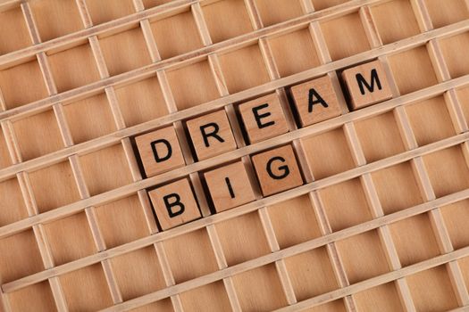 Inspirational message 'Dream Big' on wooden Scrabble tiles arranged creatively.