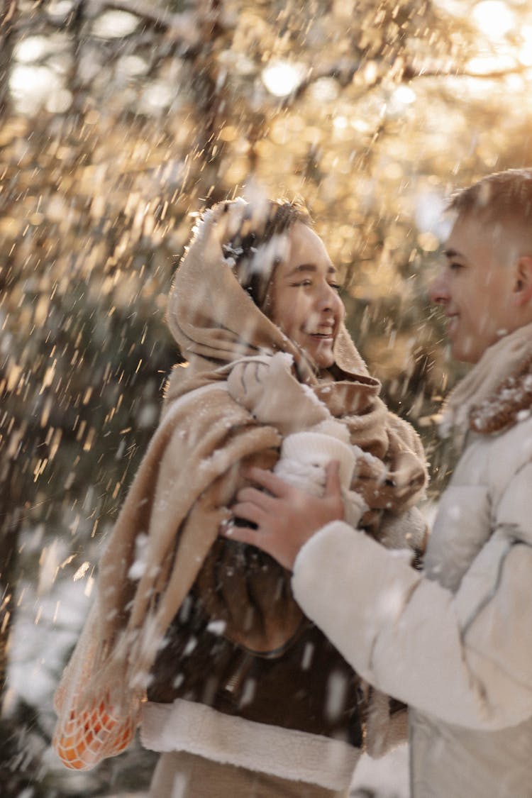 Woman And Man Smiling And Hugging In Snow