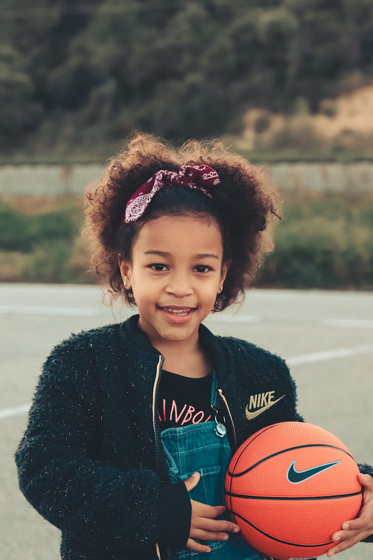 A Girl In Black Sweater Holding A Basketball