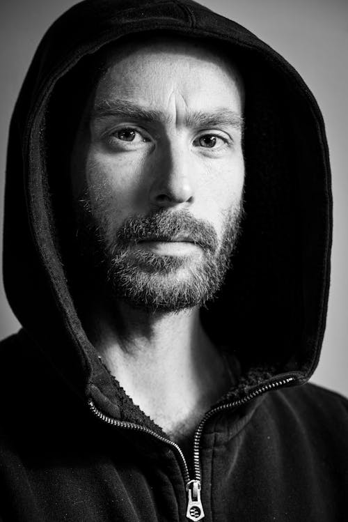 Free Grayscale Photo of a  Man in Black Hoodie with a Pensive Facial Expression
 Stock Photo