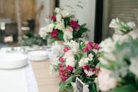 婚礼桌上点缀着粉红与白玫瑰的美丽花卉装饰，非常适合这场浪漫的庆祝