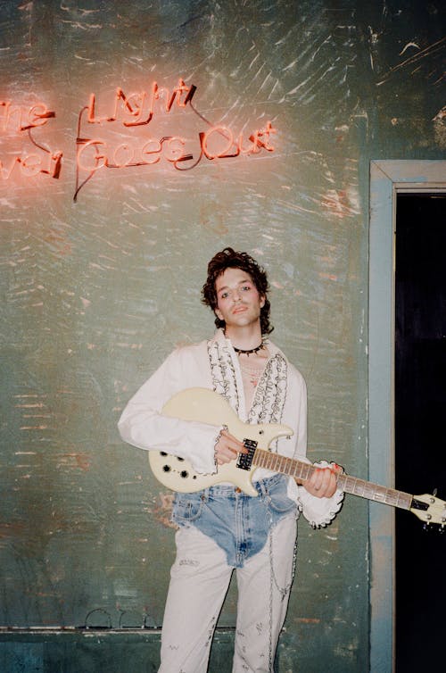 Man in White Long Sleeve Shirt Holding White Electric Guitar