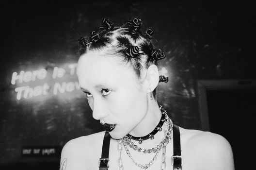 

A Grayscale of a Woman Wearing Necklaces and a Choker