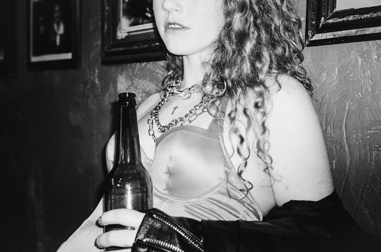 
A Grayscale Of A Woman Drinking A Beer