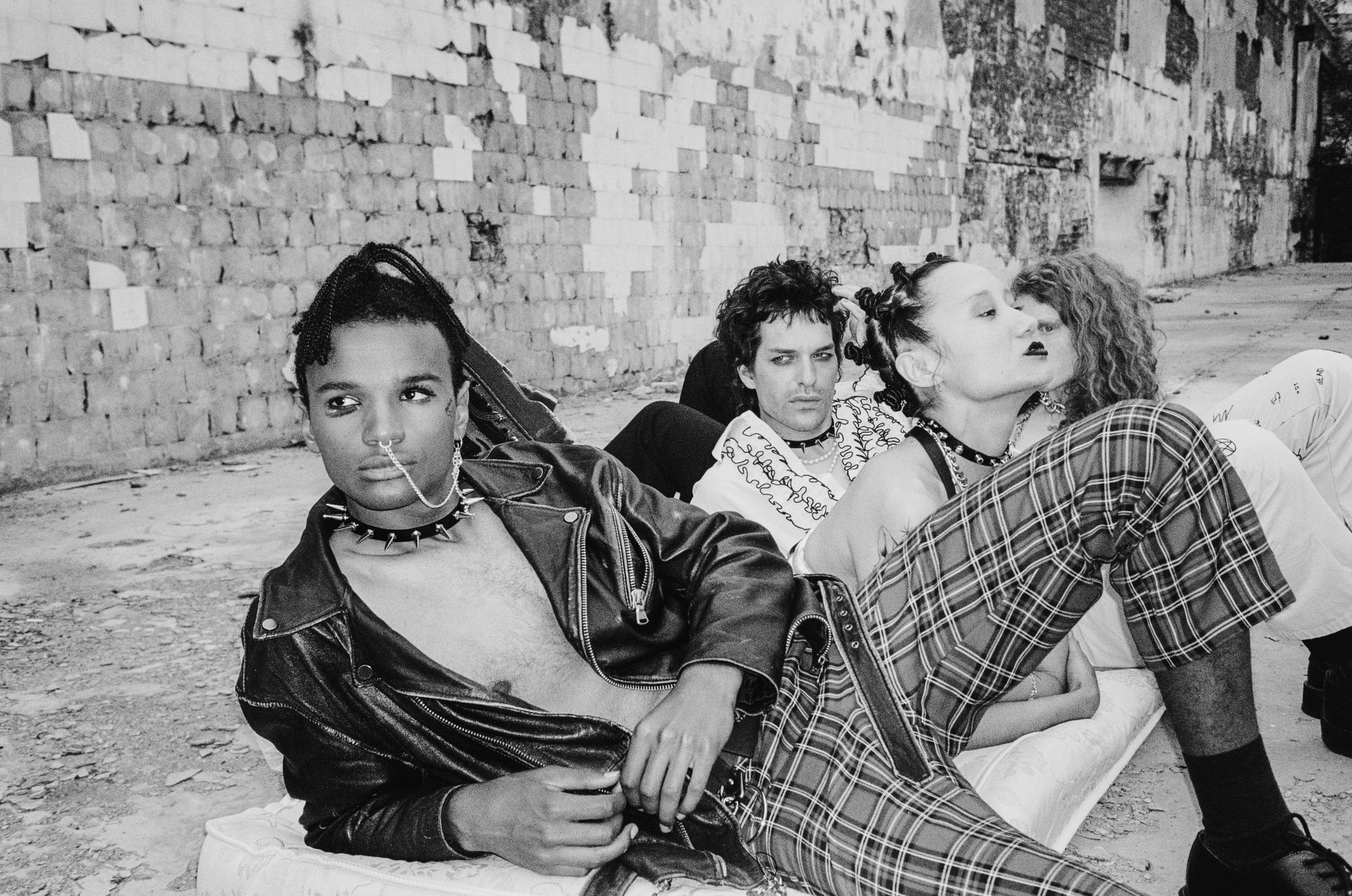 Grayscale Photo of People Lying on Mattress on Concrete Floor