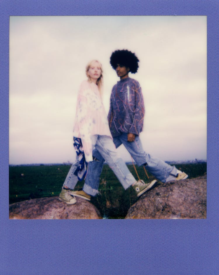 Couple Standing Over Gap In Rock