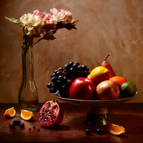 Red and White Grapes on Brown Wooden Bowl Beside Orange Fruit on Brown Wooden Table
