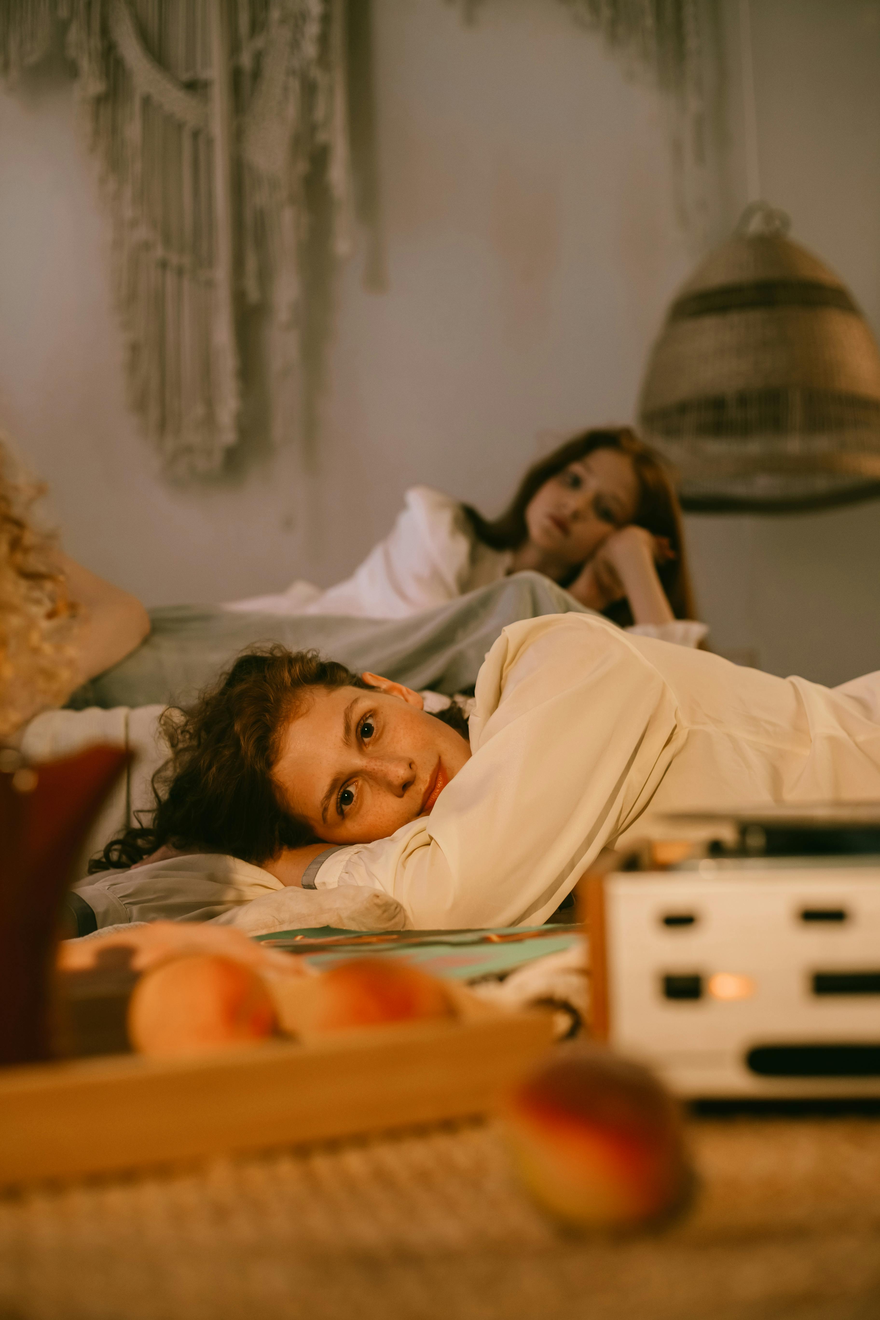 two women lying and listening to music