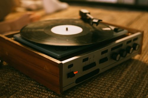 Free Close-up of a vintage vinyl record player on a textured rug, highlighting analog music ambiance. Stock Photo