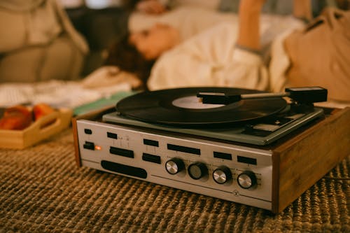 Vinyl Record Player and Women Listening to Music in the Background