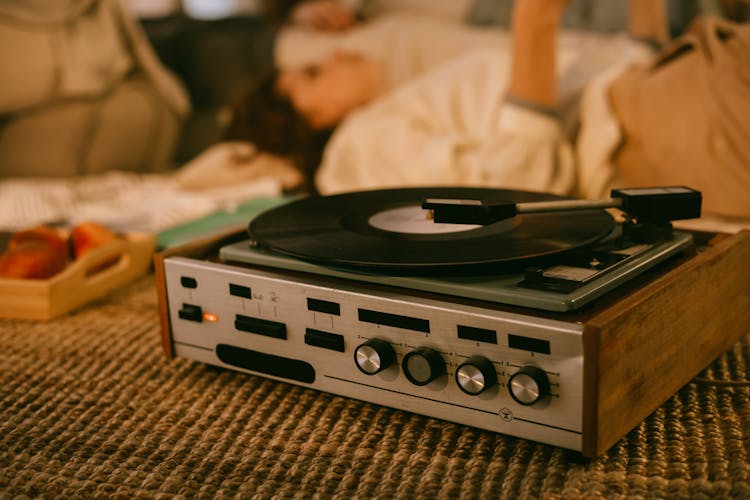 Vinyl Record Player And Women Listening To Music In The Background