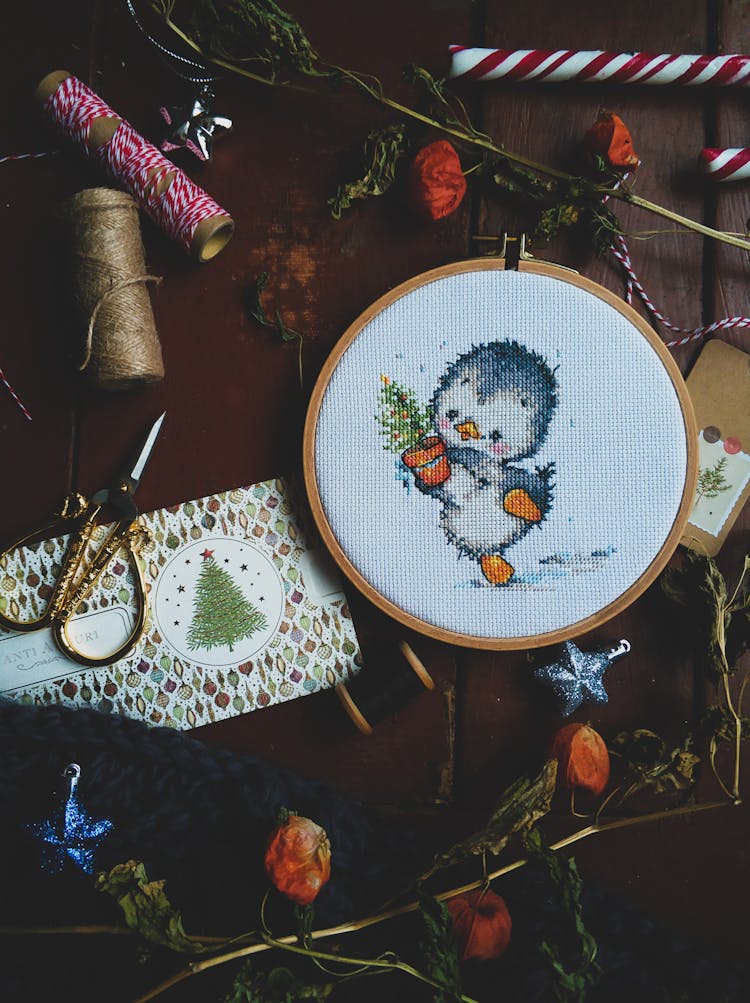 A Cute Cross Stitch Project On A Wooden Surface