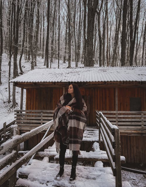 Brunette Woman in Front of Log Cabin