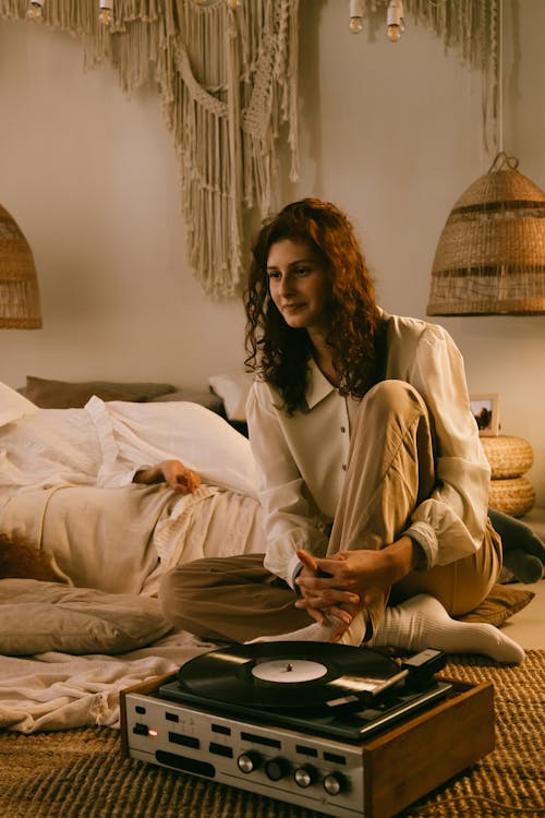 Smiling Redhead and Vinyl Record Player on Bed