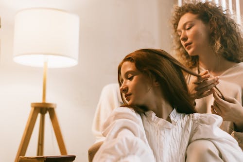 Woman Braiding Teenage Girl Hair