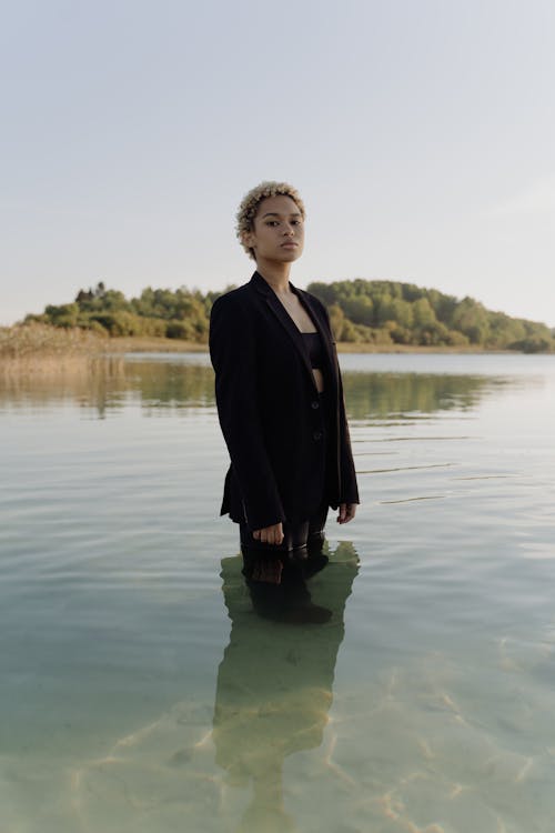 Free Woman Wearing Black Blazer Standing on Shallow Water Stock Photo