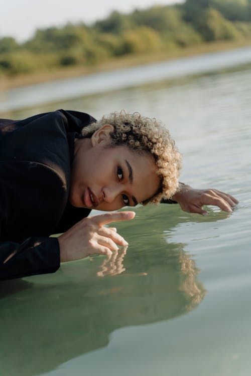 Woman Bending Above Lake Surface