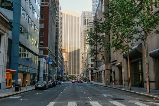 Lively downtown San Francisco street with buildings and cars during daytime.