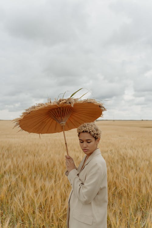 Woman Holding Umbrella on a Field 