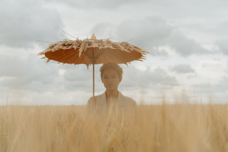 Woman Holding Umbrella On Brown Field 