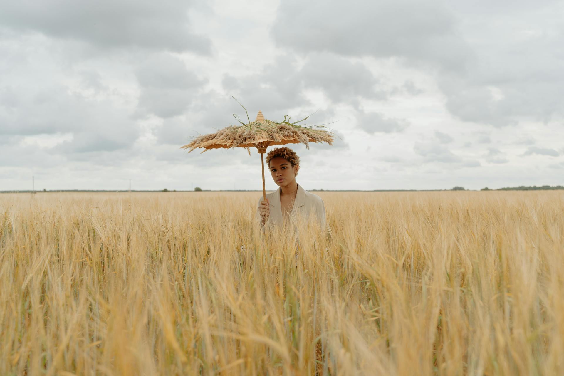 Woman Holding an Umbrella on Grass Field