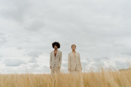 Free Man and Woman Standing on Brown Grass Field Stock Photo