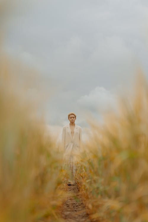 Free Man in White Suit Standing on Brown Grass Field Stock Photo