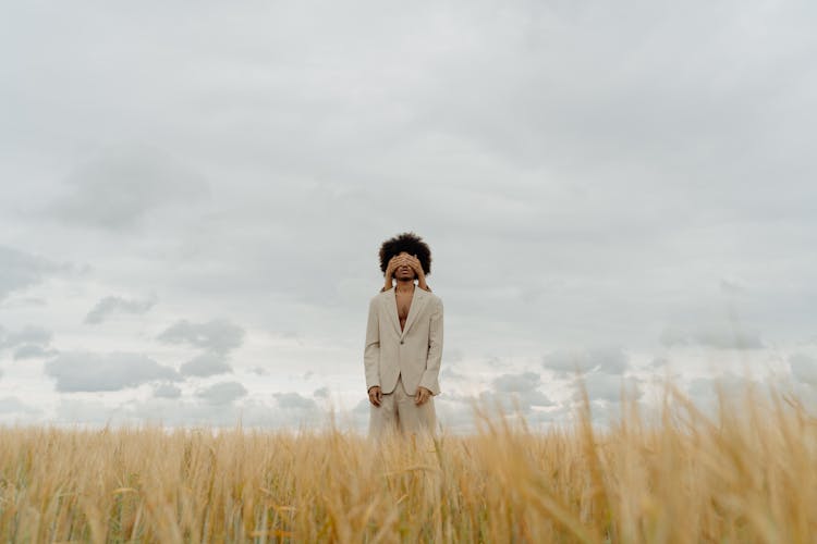 A Person Covering A Young Man's Eyes In A Rye Field