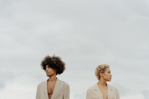 Free Two stylish models with natural hair pose outdoors, embracing a modern fashion aesthetic. Stock Photo