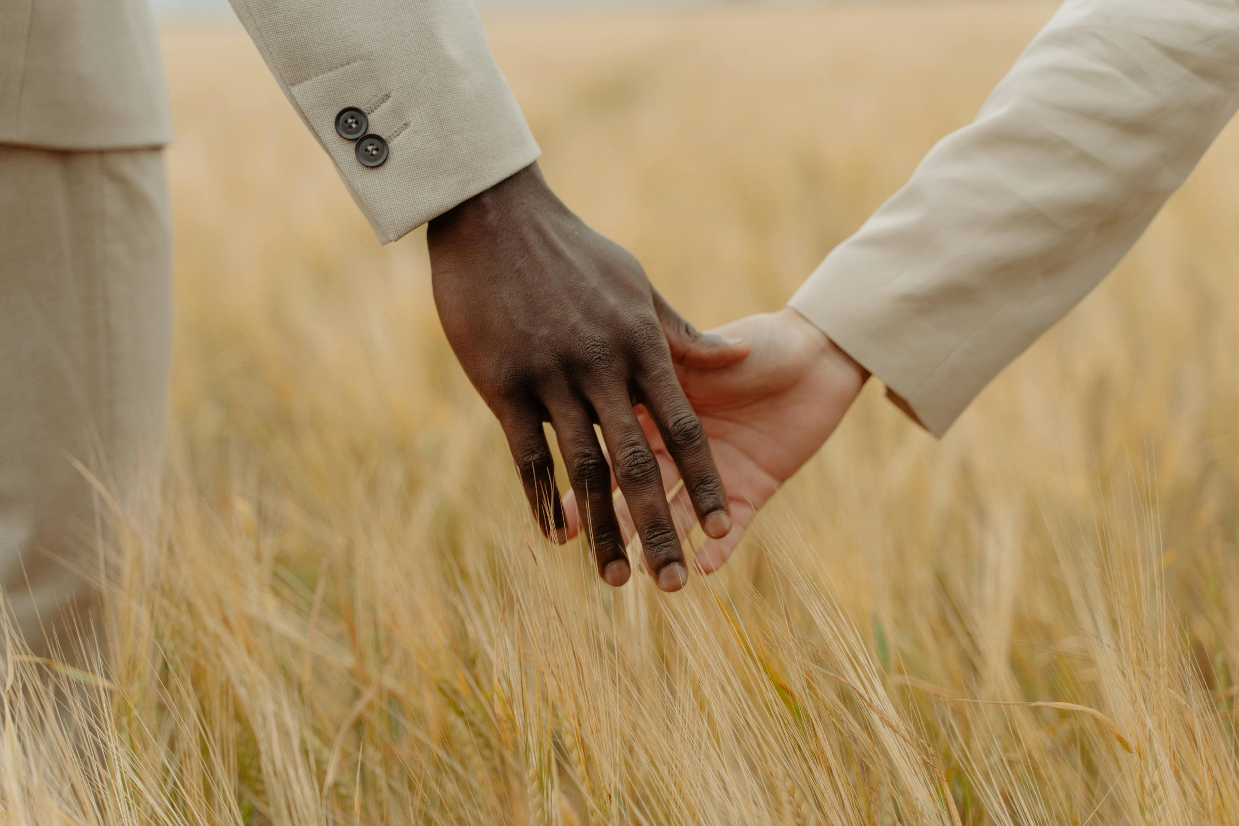 man and woman hands on field