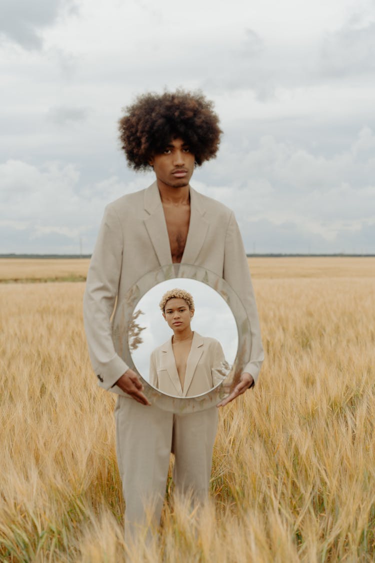 A Man In Beige Suit Holding A Mirror