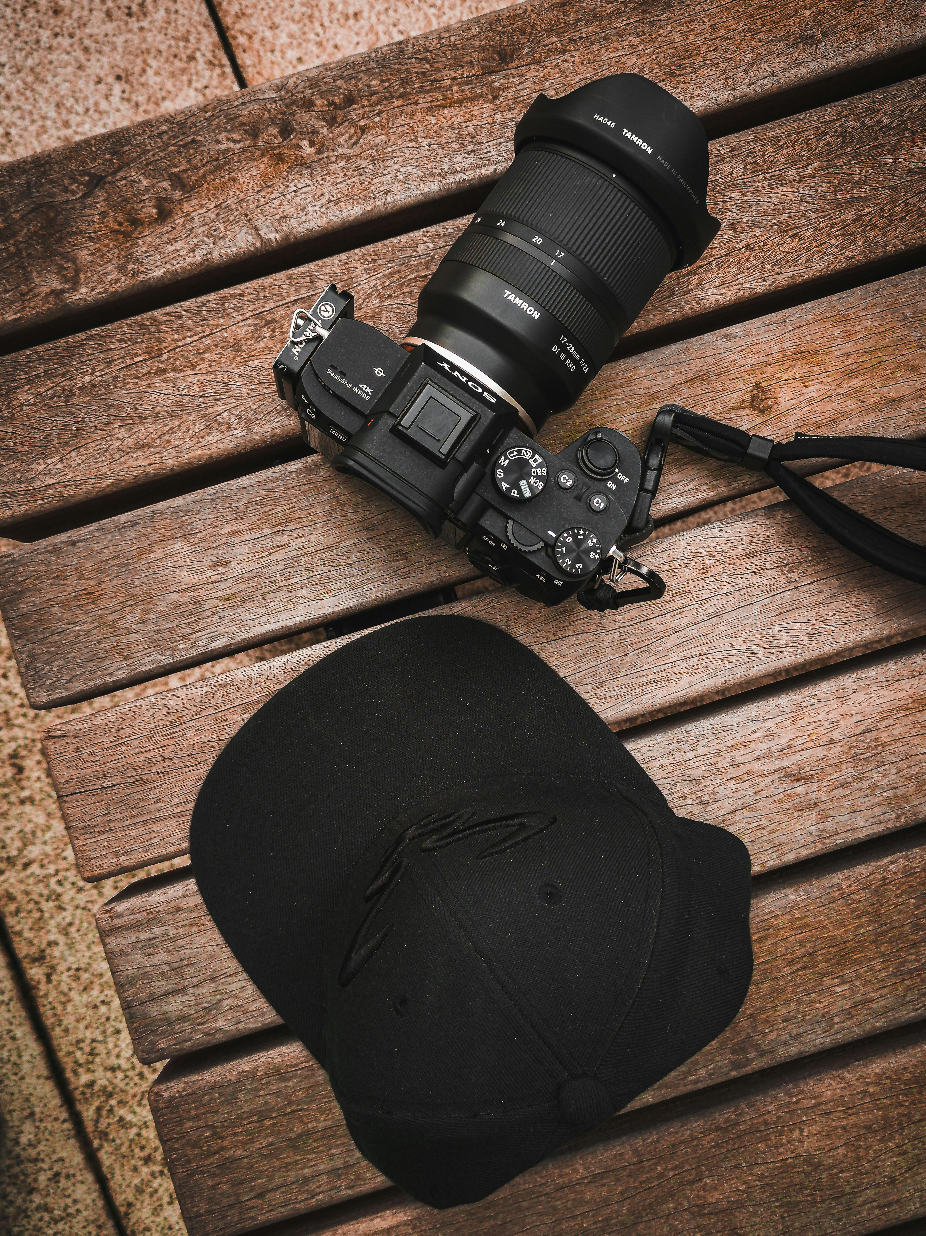 black cap and camera on wooden surface