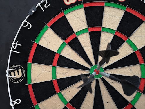 A Close-up Shot of a Dartboard with Darts on the Bullseye 