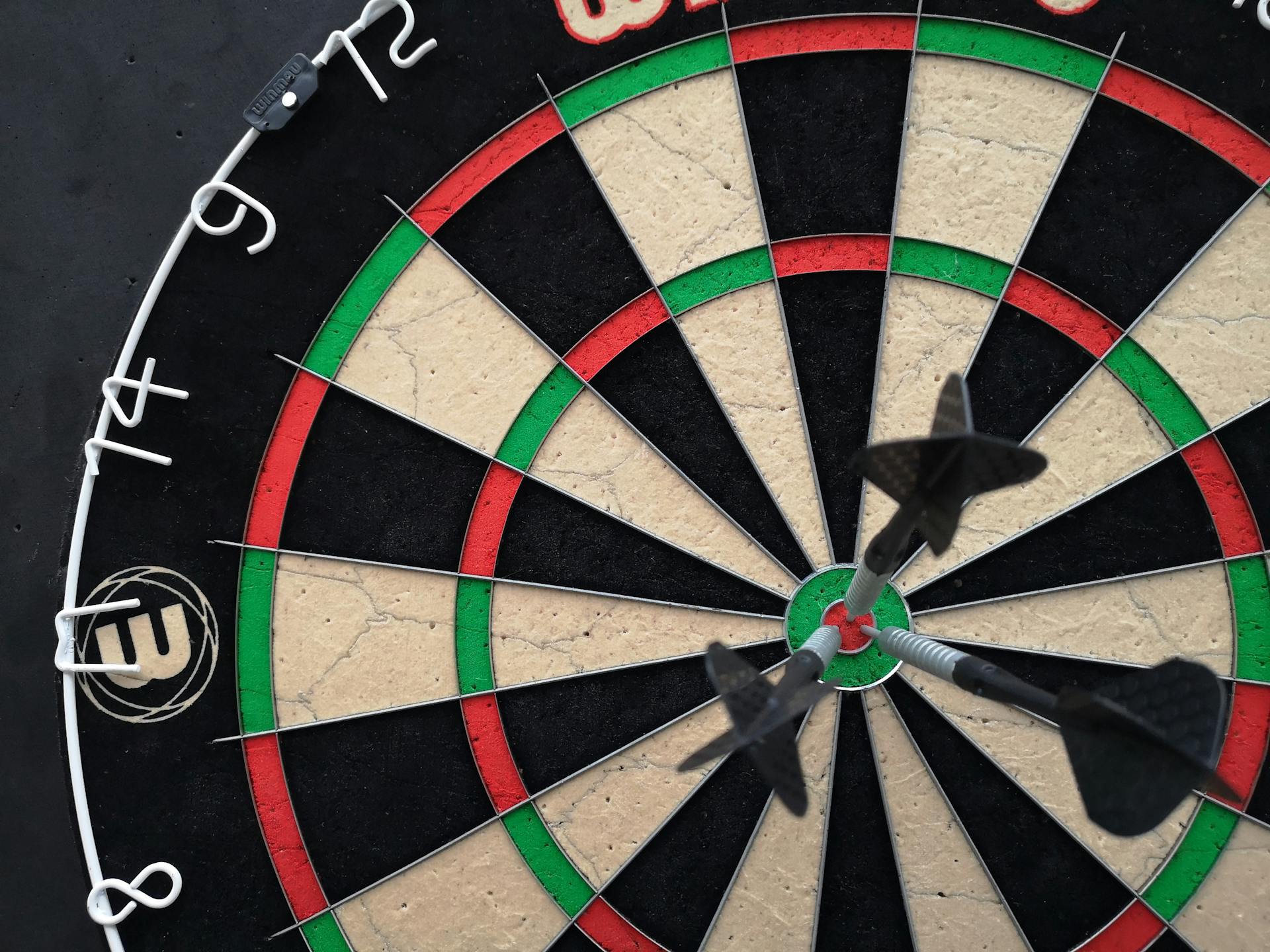 A Close-up Shot of a Dartboard with Darts on the Bullseye